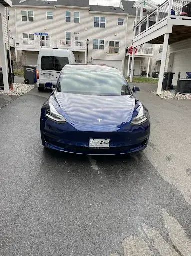 Blue Tesla Model 3 on a driveway after a detail