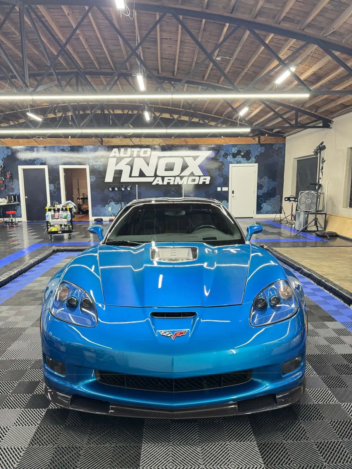 Blue Corvette with paint protection film inside Knox Auto Armor's shop