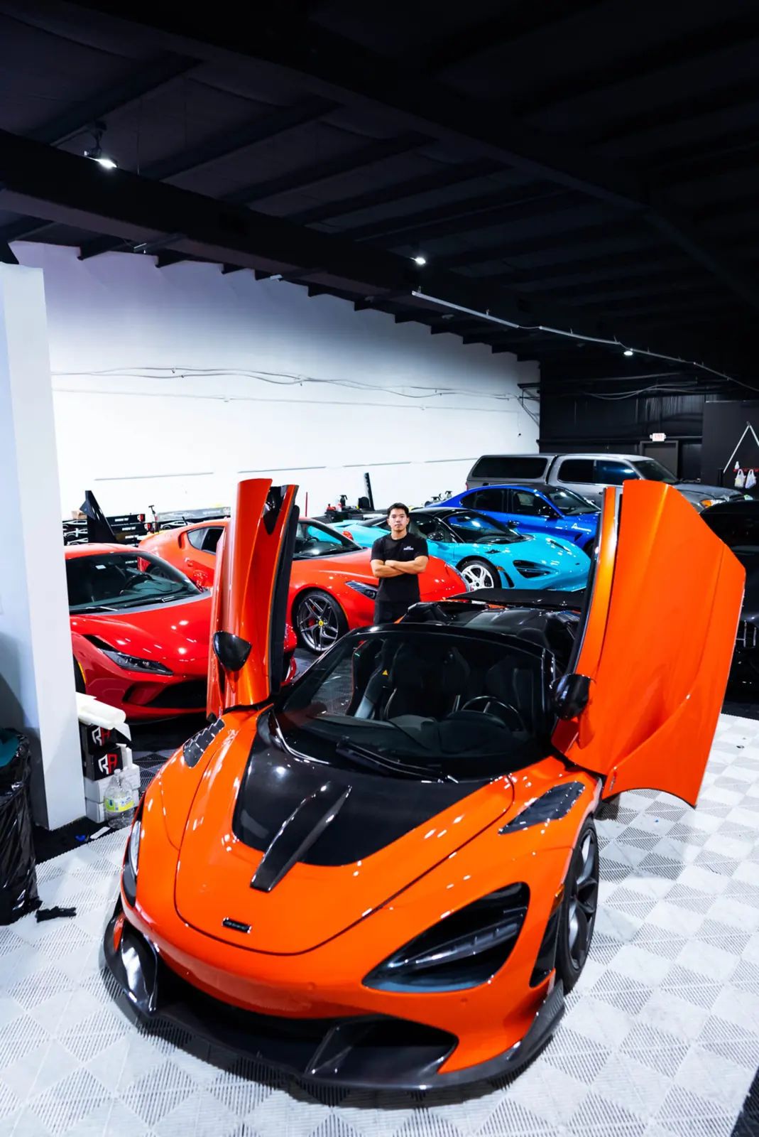 Orange McLaren with doors up in JLE Customs' shop